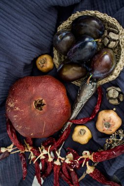 Kurumuş meyveler, sebzeler ve koyu gri desenli otlarla dolu bir hayat. Farklı nesnelerin üst görünüm fotoğrafı. Sonbaharın renkleri.