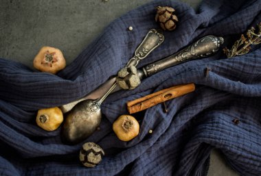 Gümüş kaşıkla, kurutulmuş meyvelerle, sebzelerle ve lacivert dokulu otlarla dolu bir hayat. Farklı nesnelerin üst görünüm fotoğrafı. Sonbaharın renkleri.