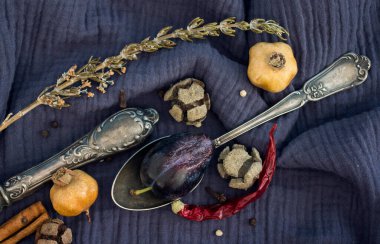 Gümüş kaşıkla, kurutulmuş meyvelerle, sebzelerle ve lacivert dokulu otlarla dolu bir hayat. Farklı nesnelerin üst görünüm fotoğrafı. Sonbaharın renkleri.