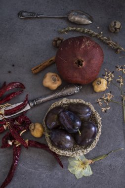 Kurumuş meyveler, sebzeler ve koyu gri desenli otlarla dolu bir hayat. Farklı nesnelerin üst görünüm fotoğrafı. Sonbaharın renkleri.