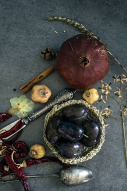 Kurumuş meyveler, sebzeler ve koyu gri desenli otlarla dolu bir hayat. Farklı nesnelerin üst görünüm fotoğrafı. Sonbaharın renkleri.