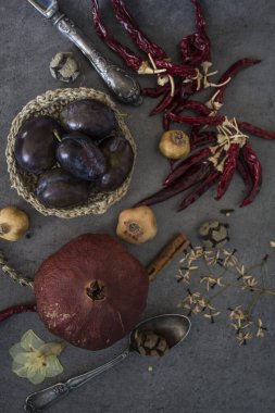 Kurumuş meyveler, sebzeler ve koyu gri desenli otlarla dolu bir hayat. Farklı nesnelerin üst görünüm fotoğrafı. Sonbaharın renkleri.