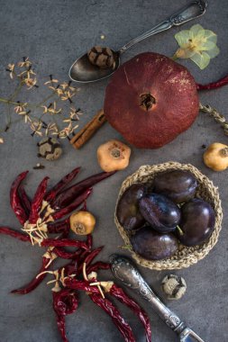 Kurumuş meyveler, sebzeler ve koyu gri desenli otlarla dolu bir hayat. Farklı nesnelerin üst görünüm fotoğrafı. Sonbaharın renkleri.