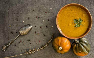 Gri masada balkabağı çorbası ve gümüş kaşık. Vejetaryen yemeğinin en iyi görüntüsü. Sağlıklı yeme kavramı. 