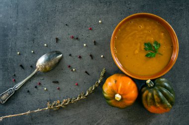 Gri masada balkabağı çorbası ve gümüş kaşık. Vejetaryen yemeğinin en iyi görüntüsü. Sağlıklı yeme kavramı. 