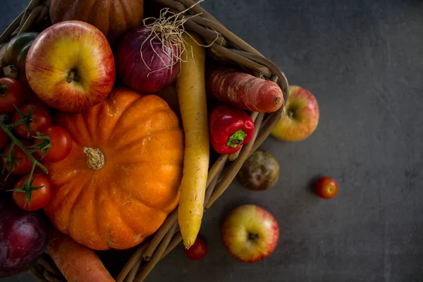 バスケットの新鮮な庭の野菜 カボチャ リンゴ ニンジン チェリートマトと赤玉ねぎ 秋の収穫写真 濃い灰色の背景 — ストック写真