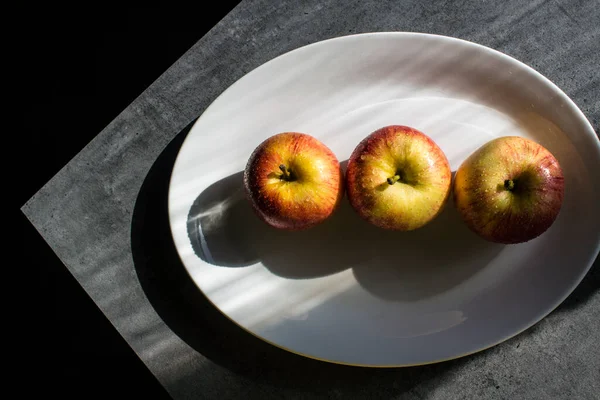 Three Apples White Oval Plate Dark Background — Stock Photo, Image