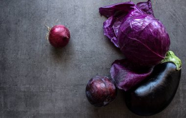 Kırmızı lahana, patlıcan ve soğan gri masada.. 