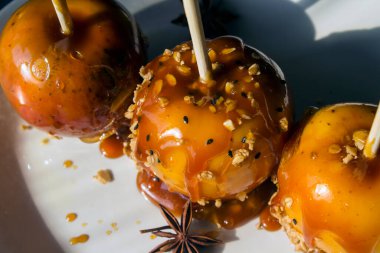 Çubukta üç karamelli elma. Ev yapımı Cadılar Bayramı tatlıları.