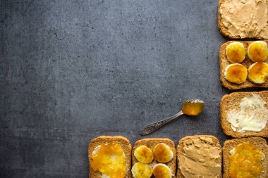 Farklı malzemelerle yapılmış tost ekmeğinden yapılmış çerçeve ya da sınır. Güzel kahvaltı manzaralı fotoğraf. Kopya alanı ile koyu gri desenli arkaplan.