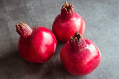 Koyu gri arkaplanda üç nar ve fotokopi alanı. Kırmızı meyveli fotoğraf. Yahudi Yeni Yılı Sembolleri.  