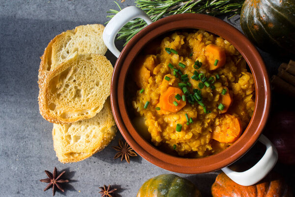 Vegetarian pumpkin stew in white ceramic pot. Homemade balanced dish. Healthy eating concept. 