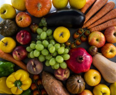 Masada taze sonbahar meyveleri ve sebzeleri. Narlar, üzümler, kabaklar, elmalar ve havuçlar.. 