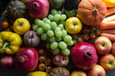 Masada taze sonbahar meyveleri ve sebzeleri. Narlar, üzümler, kabaklar, elmalar ve havuçlar.. 