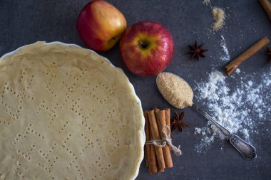 Elmalı turta hazırlığı. Taze elmalar, kabartma şeklinde hamur, tarçın çubukları, şeker ve un.. 