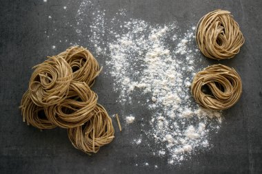 Makarna hazırlıyorum. Üst görüntüdeki taze malzemeler. Koyu gri arkaplan.