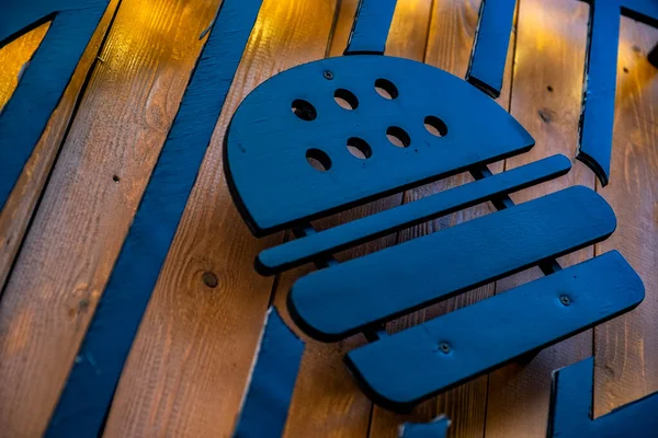 Kahverengi ahşap arka planda düz metal siyah hamburger figürü. Restoranlarda, barlarda, yemek salonlarında tasarlanan iç veya dış mekanlarda kullanılabilen sembol veya amblem.