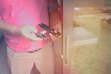 Erkekler alüminyum kapı çilingirlerinin parçalarını saklar. Kurulum, ayar ya da onarım için alüminyum kapı kilidi montajı. Cam güneş ışığı, tahmin et gölge. Kapı kilitleme mekanizması teknisyeni.