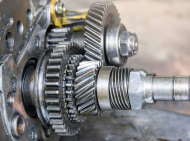 Motor dişlisi tekerlekleri, araba vites kutusunun yedek parçası tamir ve onarım için çıkarılmış, endüstriyel arka plan.