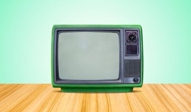 yeşil retro eski televizyon alıcısı masanın ön tarafında yeşil duvar arkaplanı.