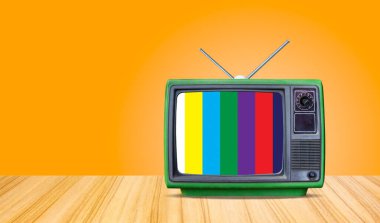 yeşil retro eski televizyon alıcısı ve ön masa gradyan turuncu duvar arka planı, perspektif ahşap zemin dokusu ve klasik televizyon.