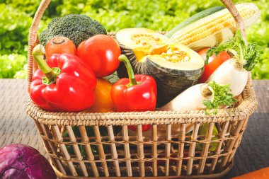 Tahta bir sepete yerleştirilmiş çeşitli organik sebzeler..