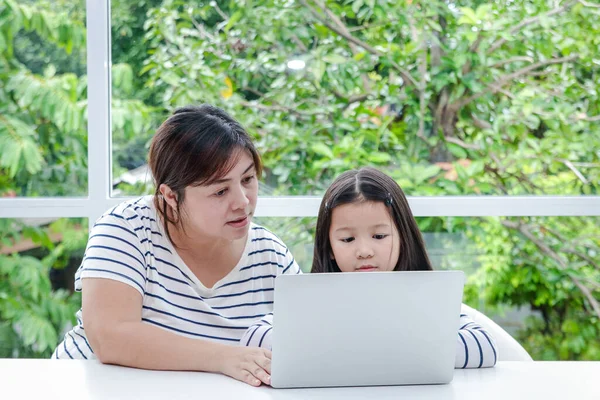 母亲教一个年轻的亚洲女儿在家里用笔记本电脑在线学习 教育概念 社会距离以减少头孢病毒的传播 Covid — 图库照片