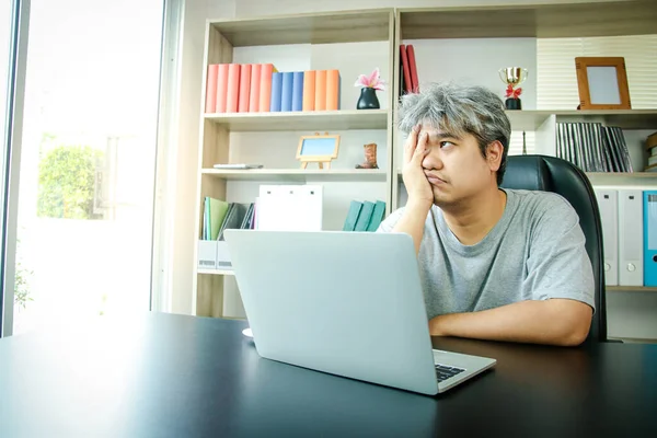 Asian people work at home in the office. There is stress meeting online work on notebook computers. The concept of entrepreneur, freelance, social distancing against coronavirus (covid-19)