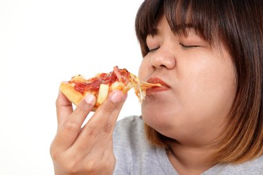 Şişko Asyalı kadın mutlu bir şekilde pizza yiyor. Kilo verme kavramı, vücut ve sağlık için iyi olan yiyecekleri seçme kavramı. Beyaz arka plan. izole