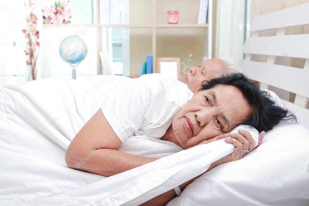 An elderly woman in bed with a lover She has stress, discomfort. Insomnia is sick. Health care concept