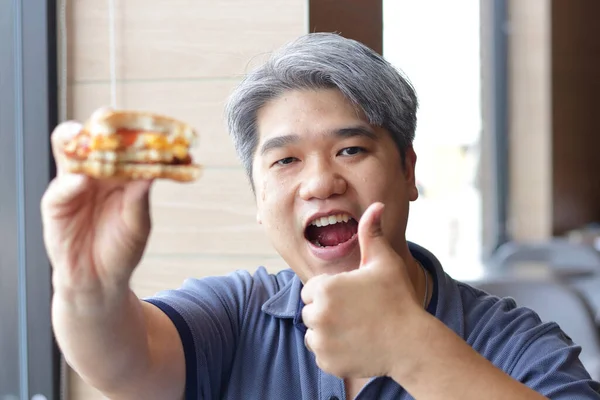 Asiatisk Fet Man Äter Hamburgare Butiken — Stockfoto