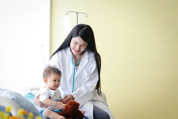 女医生在诊所检查卧床的亚洲小男孩病人 保健概念 — 图库照片