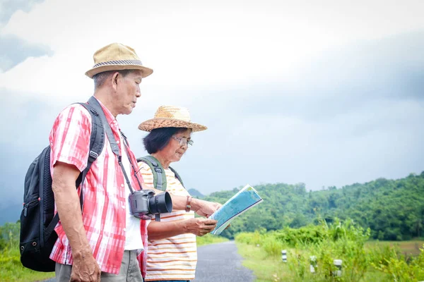 年迈的亚洲夫妇们在森林里旅行 带着地图去研究这条路线 有一个快乐 独立的生活 高级社区概念 — 图库照片