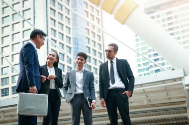 Takım elbiseli Asyalı ofis çalışanları iş yatırımlarından bahsediyorlar..