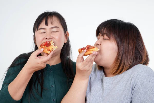 两个亚洲胖女人正在快乐地吃披萨 但对身体有负面影响 健康食品选择和健康 白色背景的概念 — 图库照片