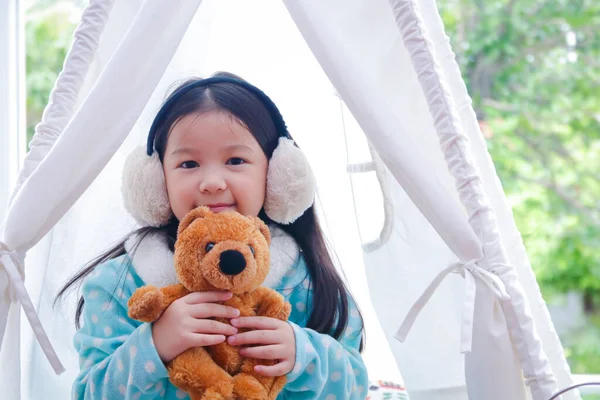 Słodka Dziewczynka Nausznikach Siedząca Przytulająca Brązowego Misia Białym Namiocie Szczęśliwa — Zdjęcie stockowe