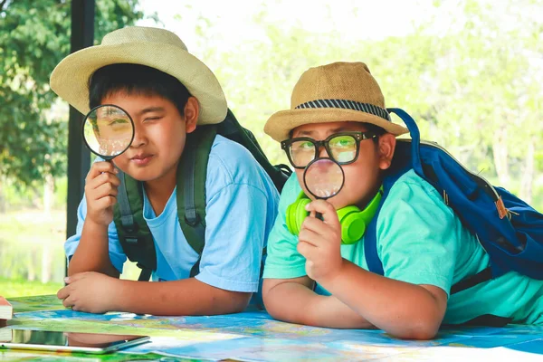 两个男孩拿着放大镜 看地图 研究自然小径旅行 儿童技能教育的概念 — 图库照片