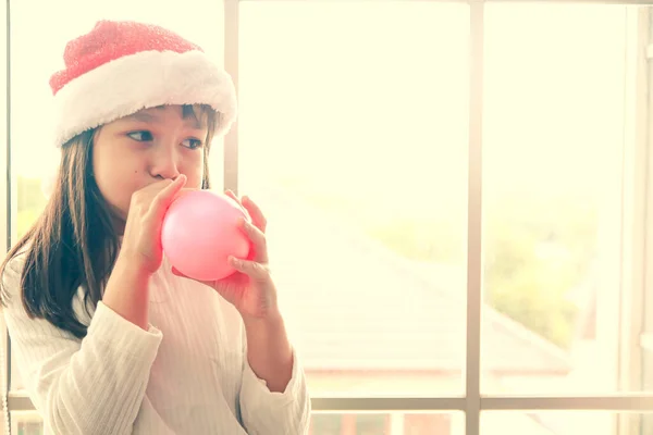 Girl Wearing Christmas Hat Stands Blowing Pink Balloons — Stock Photo, Image