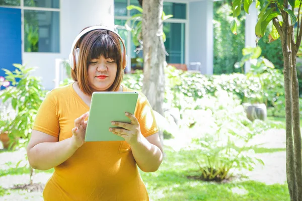 Mujer Gorda Enciende Tableta Lleva Auriculares Música Jardín Casa Concepto —  Fotos de Stock