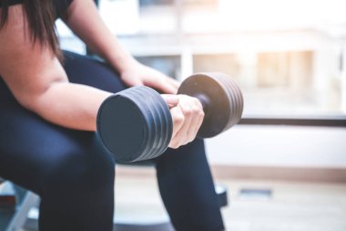 Şişman kadınlar spor yaparken dambıl kullanırlar. Güçlü sağlık için.
