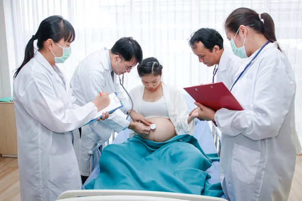 A group of doctors who take care of pregnant women closely to give birth to children safely. Hospital concept, obstetrics department and patient health care