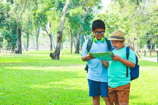 两个男孩进行实地考察 拿着世界地图去学习 — 图库照片