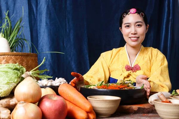 Korean women wearing traditional pink hanboks doing kimchi She is mixing the ingredients in the bowl. To taste delicious. The concept of charming fermented cooking And fragrant, Asian food — Stock Image Korean Women Wearing Traditional Pink Hanboks Doing Kimchi She Mixing Stock Image