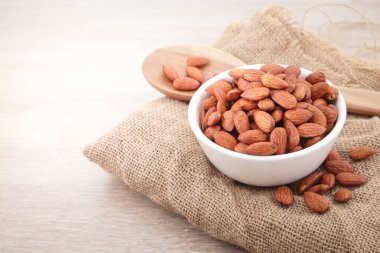 Bademler beyaz bir fincanda. Ahşap bir zemine yerleştirilmiş. Yemek fotoğrafçılığı konsepti. Uzayı kopyala Üst Görünüm