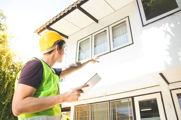 Ev inşaatçısı, bitirmeden önce ev sahibine teslim etmek için tablet taşır. Konut mimarisi kavramı