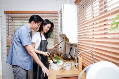 Asyalı çiftler evlerindeki mutfaklarında birlikte yemek yaparlar. Covid-19 sırasında Yaşam Konsepti, Sosyal Mesafe, kopyalama alanı