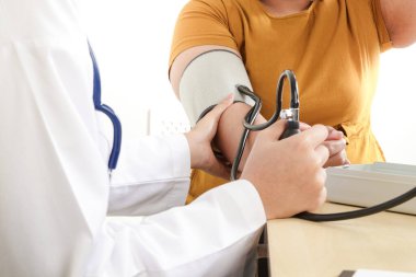 Asyalı kadın doktorlar, çok obez hastalara sağlık kontrolü ve hastalık tespiti için baskı uyguluyorlar..