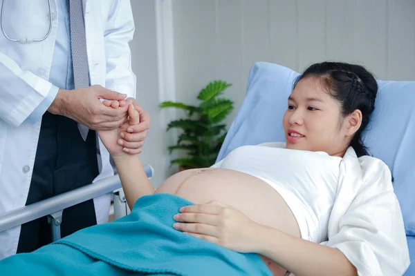 Ένας Άνδρας Γιατρός Σφίγγει Χέρι Μια Έγκυο Γυναίκα Κοντά Στη — Φωτογραφία Αρχείου