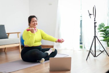 Asyalı şişman kadın blogger Egzersizi, videolar çekin, kendi içeriğinizi yayınlayın, sosyal medyada paylaşın. Modern iletişim teknolojisi kavramı.