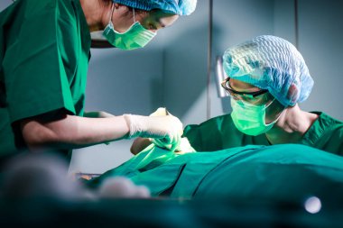 Asyalı estetik ameliyat ekibi ameliyathanede yatan bir hastaya yüz ameliyatı yapıyor. Acil ameliyat. Hastanelerde tıbbi hizmetler